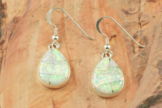 Stunning Fire and Ice Lab Opals inlaid between ribbons of Sterling Silver. Beautiful Sterling Silver French Wire Earrings feature precision channel inlay. Designed by Navajo Artist Calvin Begay. Signed.